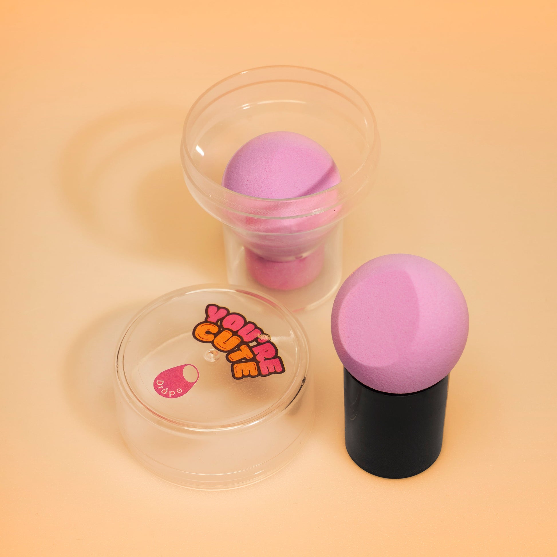 Beebee blender sminkesvamp med håndtak og reiseetui.